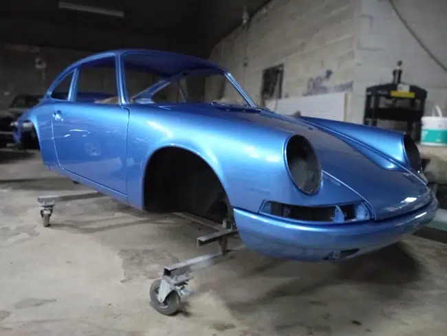 Porsche 911 bleue en cabine, carrosserie restaurée