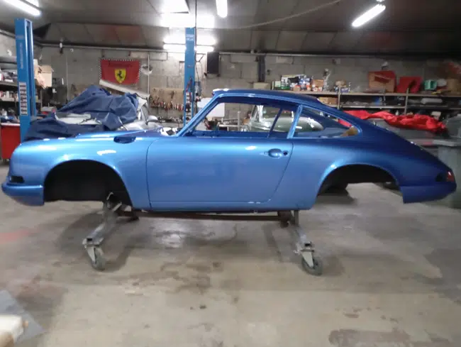 Porsche 911 bleue, vue latérale en atelier